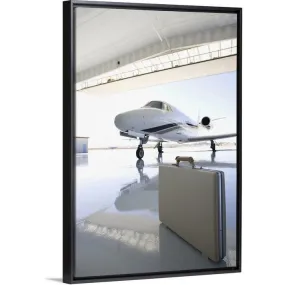 "Briefcase left in hangar near the jet" Black Float Frame Canvas Art